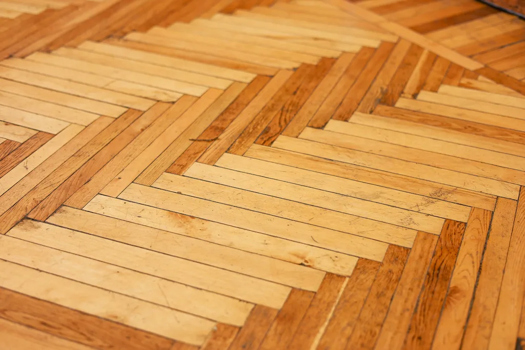 Close-up of a herringbone hardwood floor made of light and dark wood strips